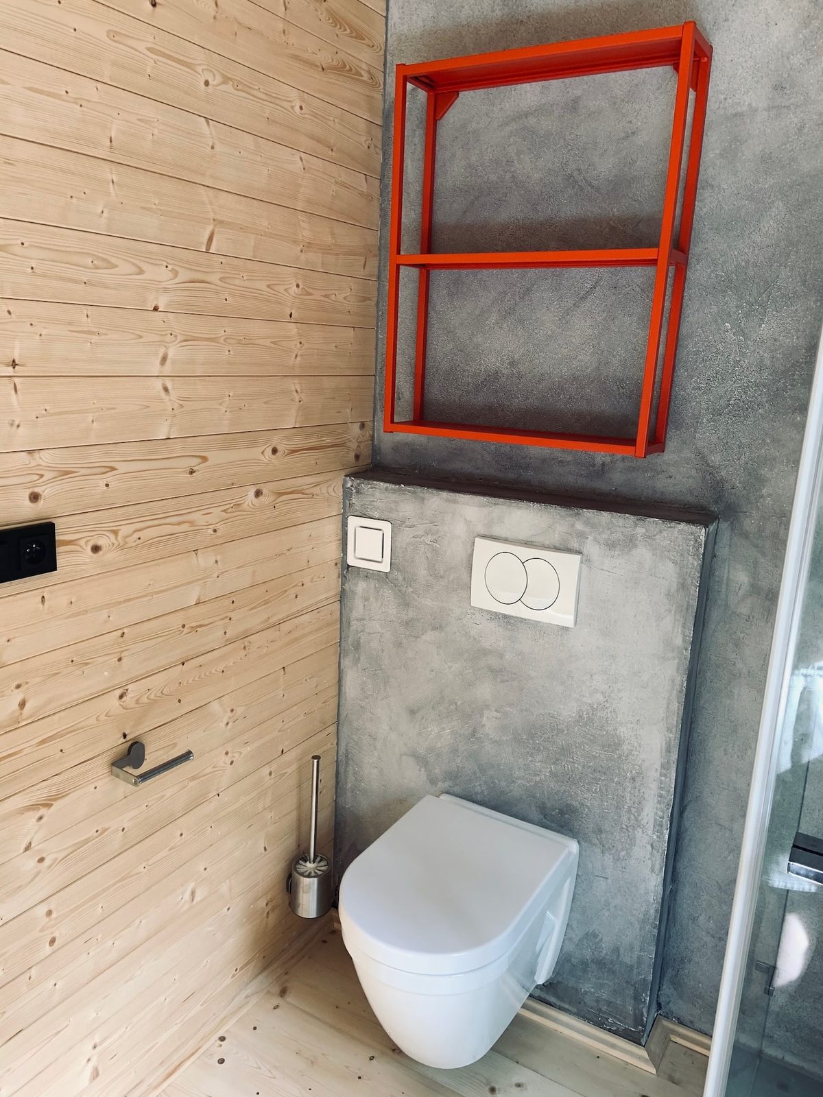 WC s červeným věšákem na ručníky